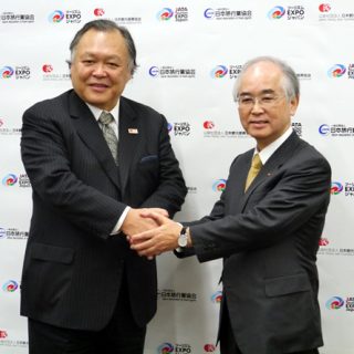 記者会見後、がっちり握手を交わす山口会長（右）と菊間会長