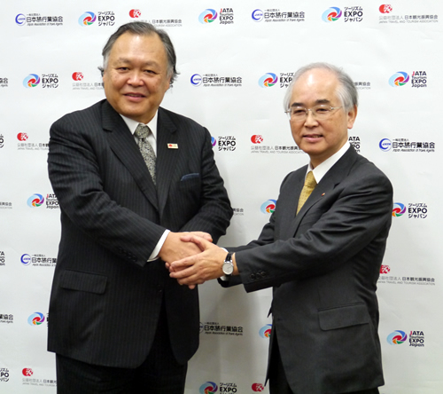 記者会見後、がっちり握手を交わす山口会長（右）と菊間会長