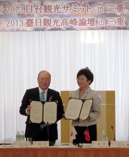 三重宣言の合意文書を手にする西田会長(左)と頼会長