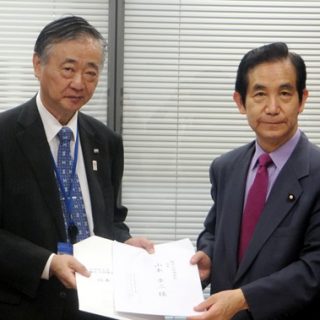 観光立国調査会の山本会長（右）に要望書を手渡す佐々木観光委員長