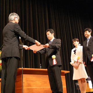 本保長官(左)から表彰を受ける米沢市立北部小学校の教諭ら