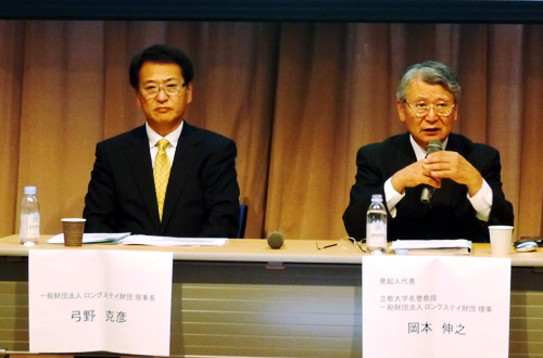 記者会見する岡本立教大名誉教授(右)と弓野理事長