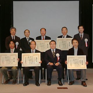 賞状を手に写真に収まる功労者
