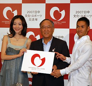 御手洗委員長(中央)とテーマソングを歌う日中歌手