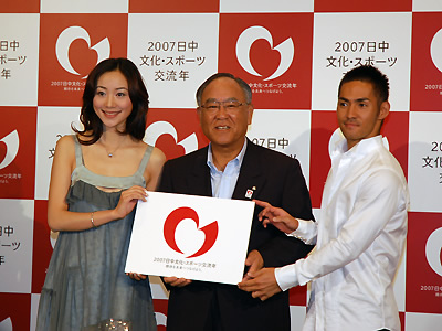 御手洗委員長(中央)とテーマソングを歌う日中歌手