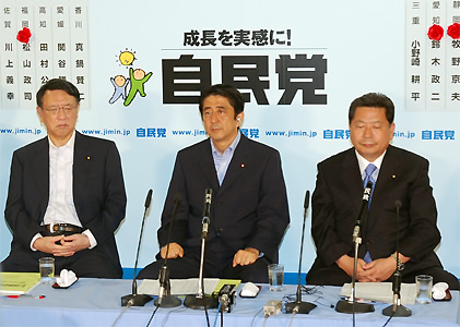 厳しい表情で報道陣のインタビューに臨む安倍首相ら（29日夜、自民党本部）