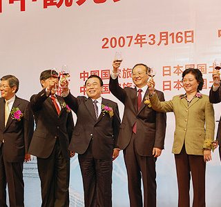 杯をかかげる冬柴国交相（右から4人目）