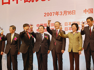 杯をかかげる冬柴国交相（右から4人目）