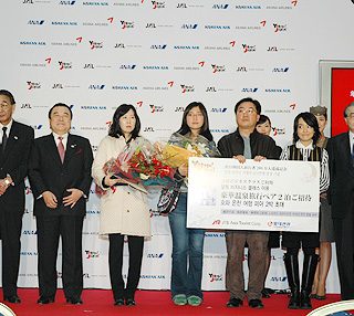 冬柴大臣(左から2人目)が出席。200万人目の観光客には記念品が贈られた