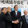 締結後ガッチリと手を握る（左から）工藤、門脇、首藤、三友の各氏