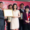 表彰式で撮影に応じる左から大町市の西沢課長、菊川さん、選定委員の桂由美さん