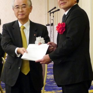 久保長官（右）に提言を渡す山口委員長＝20日、東京プリンスホテルで