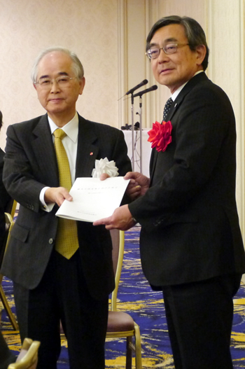 久保長官（右）に提言を渡す山口委員長＝20日、東京プリンスホテルで