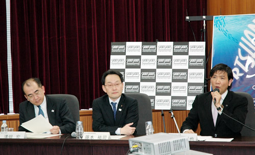 (写真右から)記者発表する別所さん、藤本政務官、溝畑長官