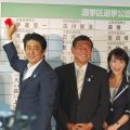 自民党本部の開票センターで当選者の名前に笑顔で花をつける安倍晋三総裁（首相）。 中央は石破茂幹事長、右端は高市早苗政調会長＝21日夜