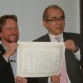 溝畑長官（右）とともに感謝状を披露するトーマスさん