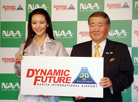 キャンペーンロゴを持つ知花さん(左)と森中社長=3月31日、都内ホテルで