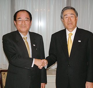 会見を終え握手する佐藤会長(右)と佐久間会長