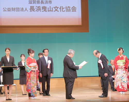 高円宮殿下記念地域伝統芸能賞を受賞し、中村会長（左）から表彰される長浜曳山文化協会の関係者 