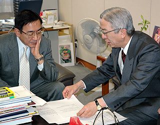 柴田審議官（左） に要望書を手渡す全旅連の小原会長=11日午前