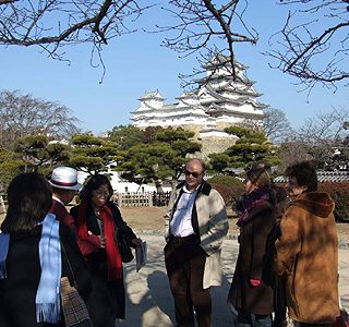 ガイドから姫路城の説明を受ける仏紙の記者ら。壮麗さに大きな関心をよせていた