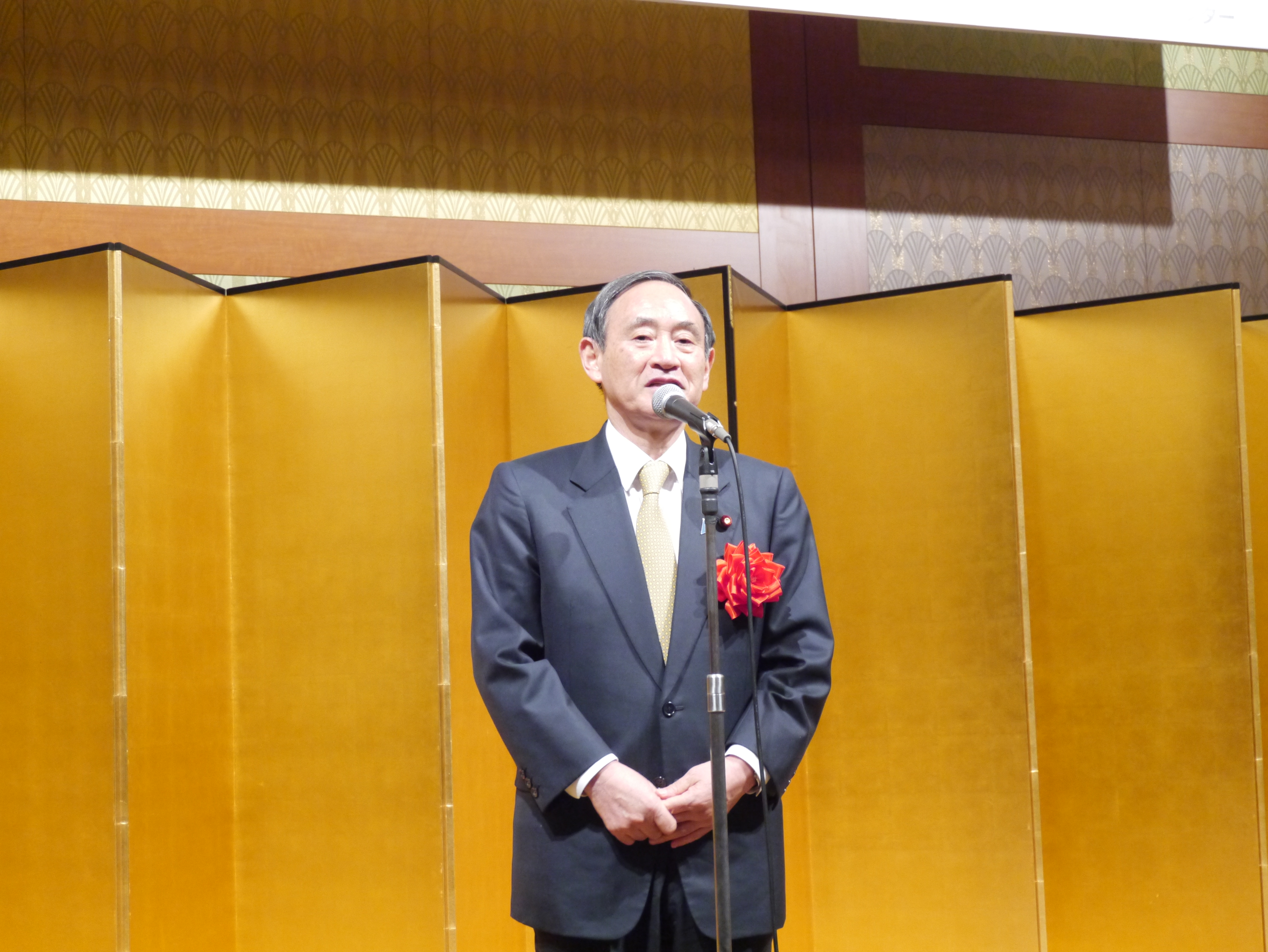 あいさつする菅官房長官