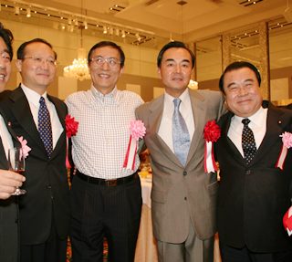 肩を組み、談笑する関係者 左から北側国交相、邵●偉中国国家旅遊局長、細田官房長官、 王毅駐日大使、冬柴公明党幹事長、二階自民党観光特別委員長 （●=王へんに其）